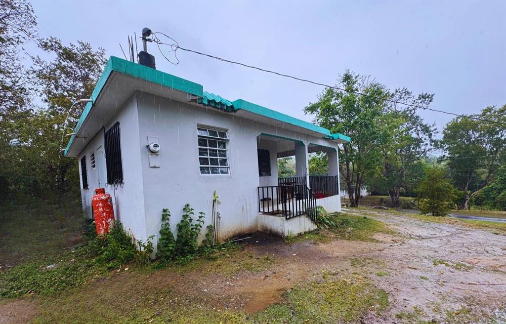 A small, white, single-story house with a green roof and a front porch — Calle #10 COMM MONTE SANTO P-2, VIEQUES, PR