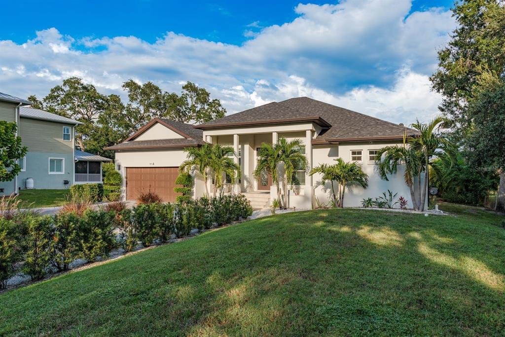 A single-story house with a brown garage, palm trees, and a grassy front lawn — 7811 BAY DRIVE UNIT A, TAMPA, FL