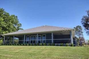 A single-story house with a large screened-in back porch sits on a grassy lawn — 13645 NW 222ND LANE, ALACHUA, FL