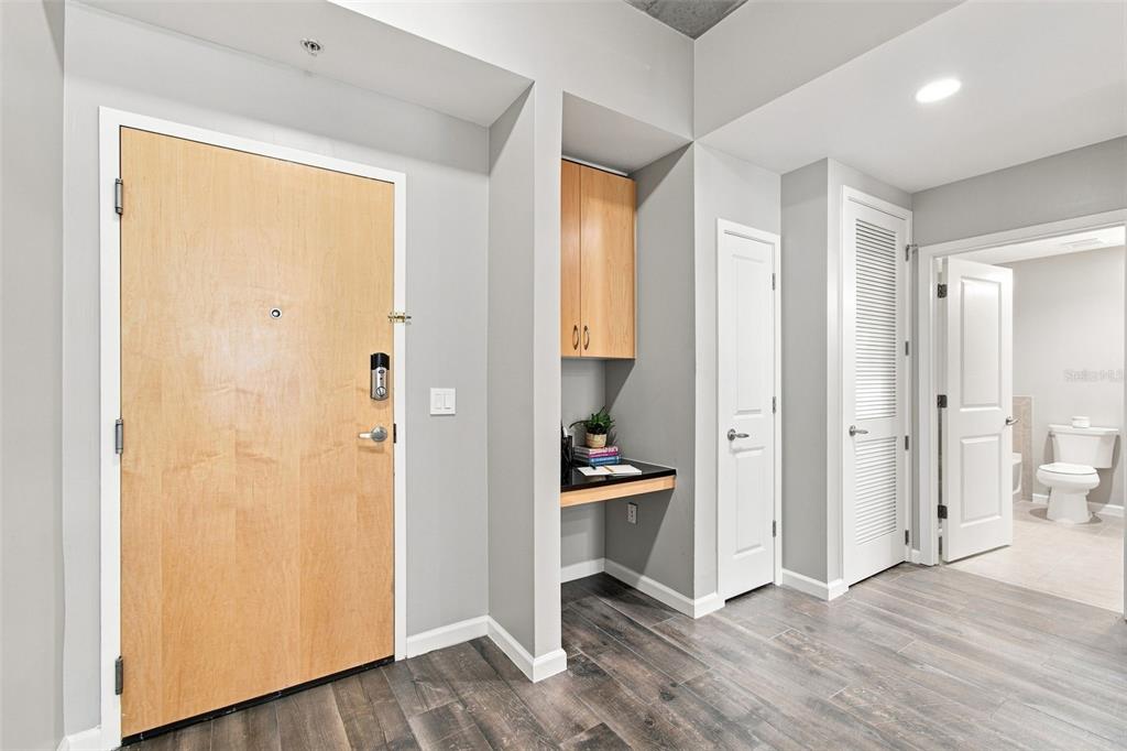 An entryway features a light wood door, a built-in desk nook, and wood-look flooring — 777 N ASHLEY DRIVE UNIT 910, TAMPA, FL