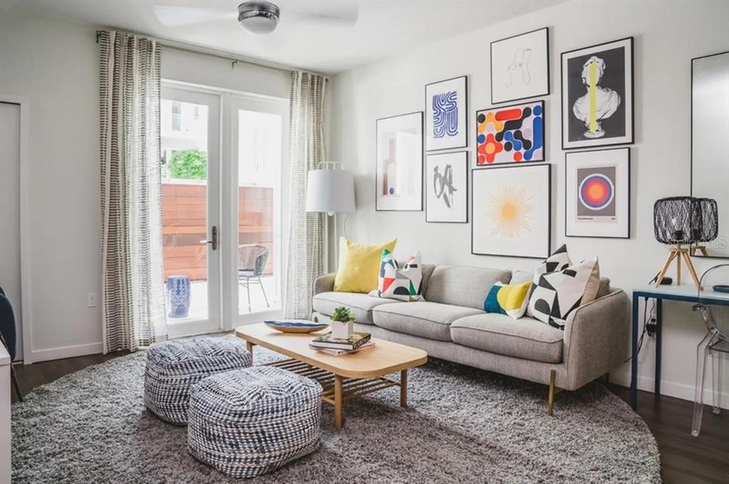 A living room features a grey sofa, coffee table, patterned poufs, and a gallery wall — 505-1 CHATHAM AVE AVENUE, ORLANDO, FL