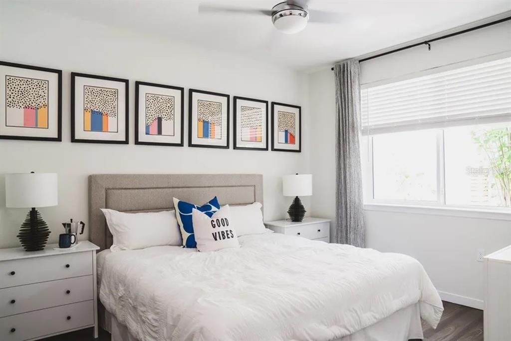 A bedroom features a bed with a gray headboard, six framed prints, and two white nightstands — 505-1 CHATHAM AVE AVENUE, ORLANDO, FL