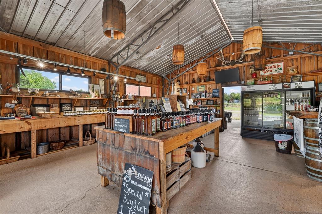 A rustic country store interior features wooden walls, barrel light fixtures, and moonshine displays — 26921 BLOOMFIELD AVENUE, YALAHA, FL