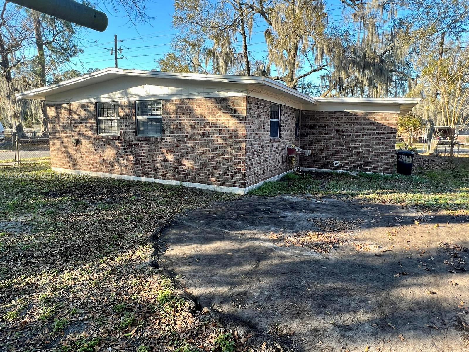 A brick house exterior features a flat roof, several windows, and a dirt yard — 2644 West, Jacksonville FL 32209, JACKSONVILLE, FL