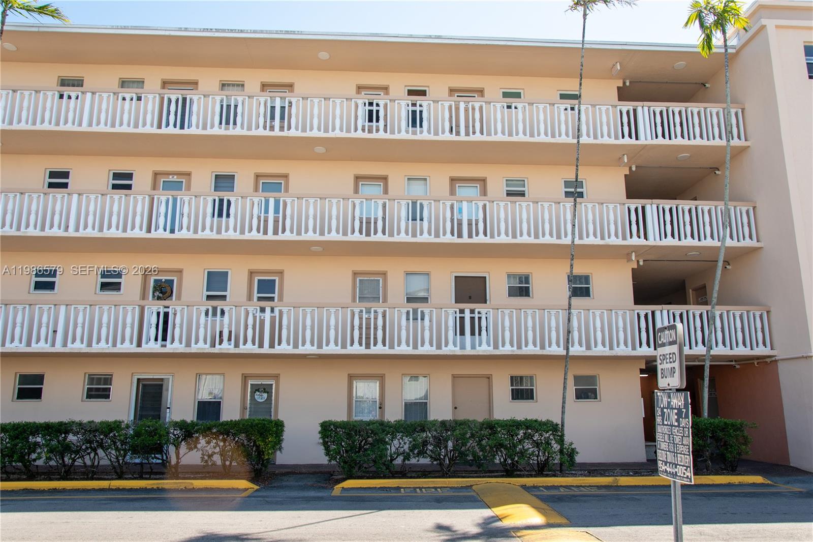 The exterior of a multi-story apartment building features beige walls and white balcony railings — 505 E Dania Beach Blvd # 2E, Dania Beach FL 33004, DANIA BEACH, FL