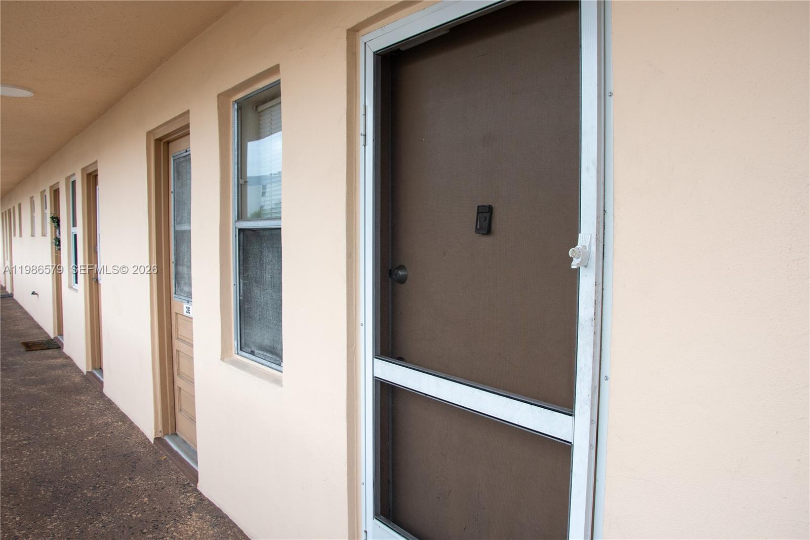 An exterior view of a building corridor featuring several doors and windows — 505 E Dania Beach Blvd # 2E, Dania Beach FL 33004, DANIA BEACH, FL