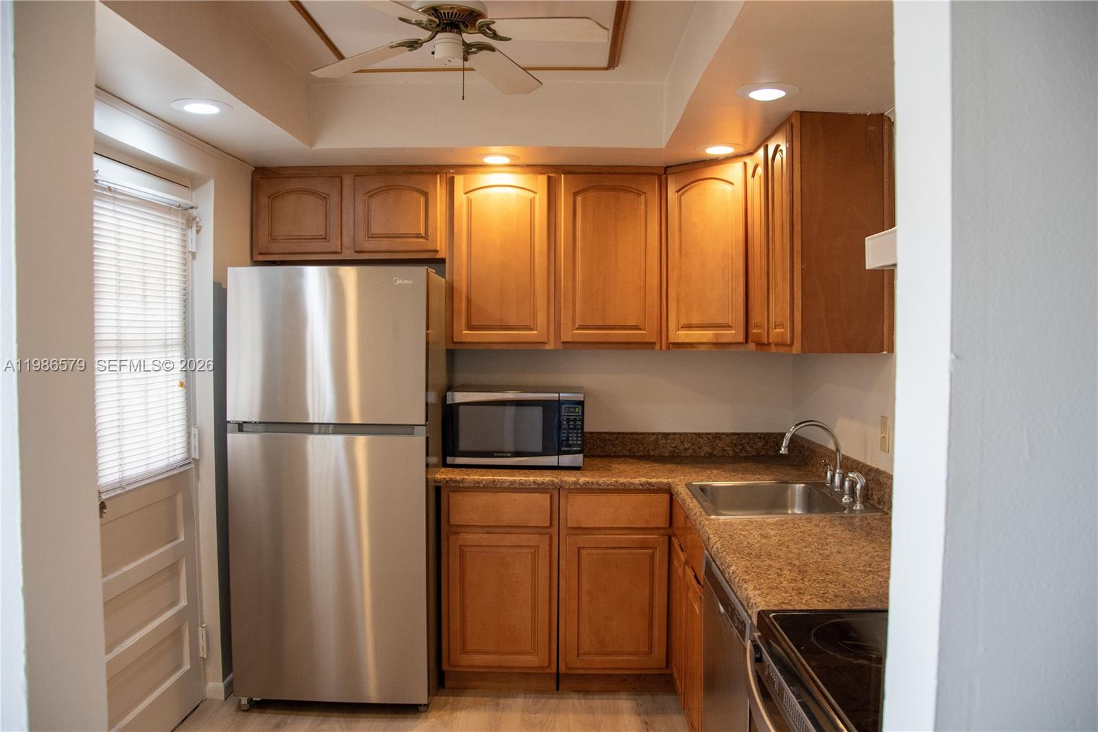 A kitchen features wooden cabinets, stainless steel appliances, and speckled laminate countertops — 505 E Dania Beach Blvd # 2E, Dania Beach FL 33004, DANIA BEACH, FL