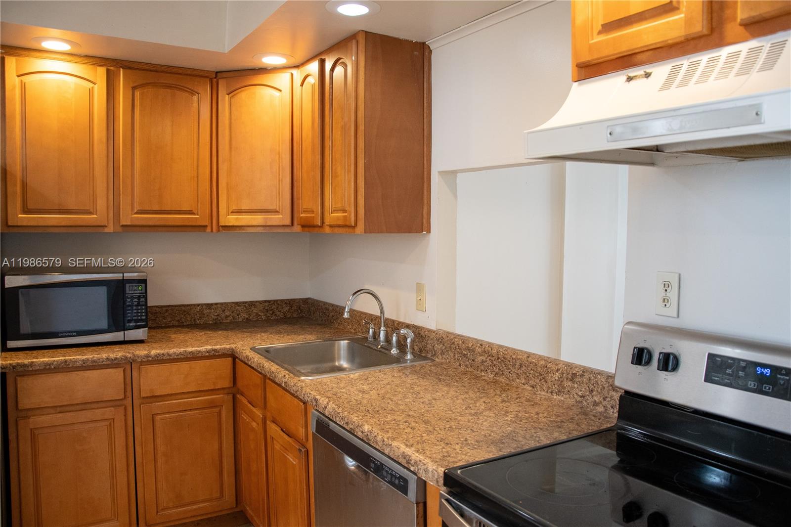 A kitchen features wood cabinets, a stainless steel sink, and a stainless steel stove — 505 E Dania Beach Blvd # 2E, Dania Beach FL 33004, DANIA BEACH, FL