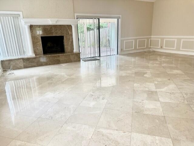 A spacious living room features polished light-colored tile floors, a marble fireplace, and sliding doors — 3021 Florida Boulevard, Delray Beach FL 33483, DELRAY BEACH, FL