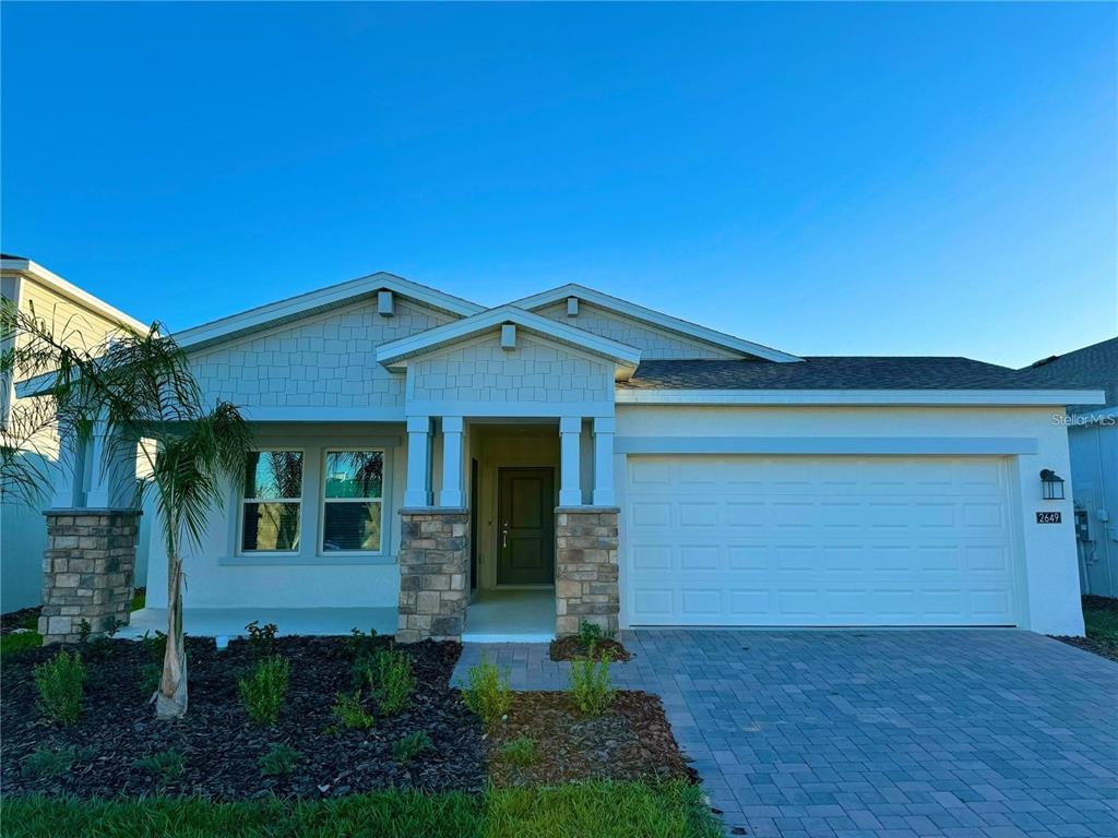 A one-story house with a stone-accented porch, a two-car garage, and a paved driveway — 2649 ARMSTRONG AVENUE UNIT A, CLERMONT, FL