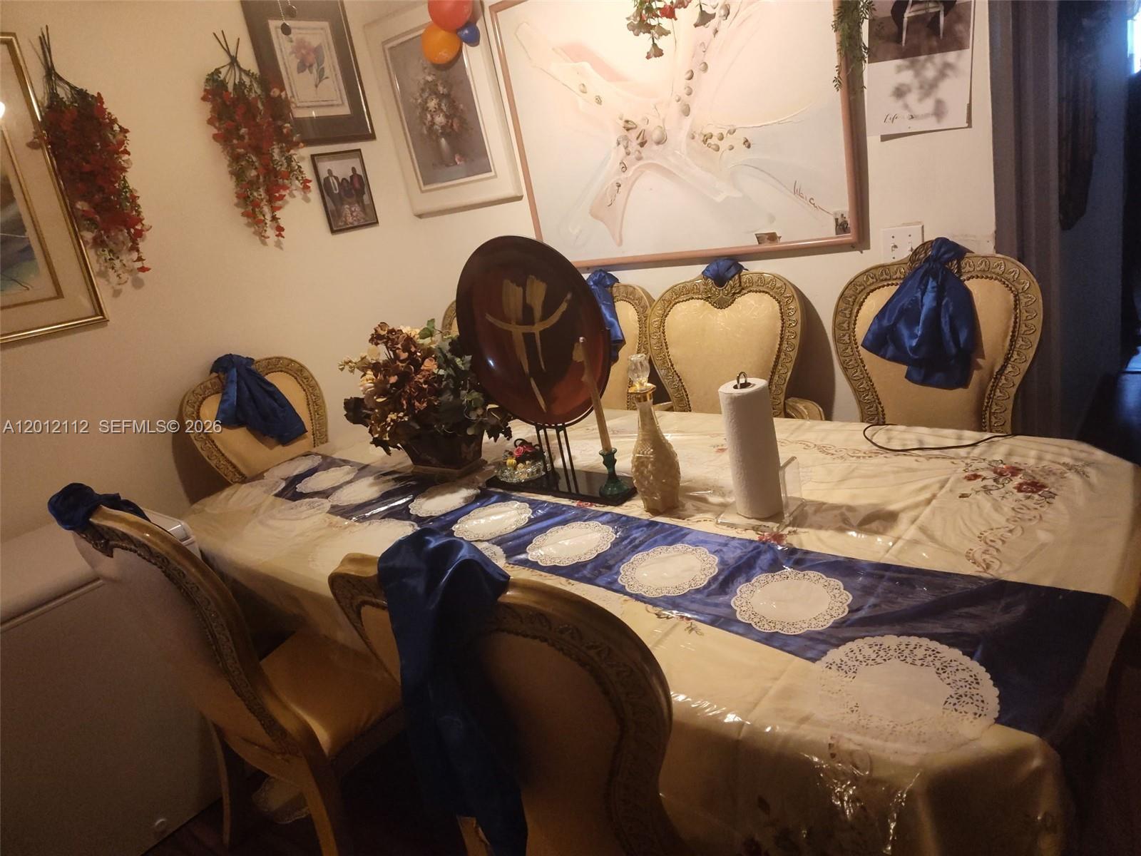 A dining room features a table with a blue runner and chairs with blue sashes — 625 SW 20th Ct # 8A, Delray Beach FL 33445, DELRAY BEACH, FL