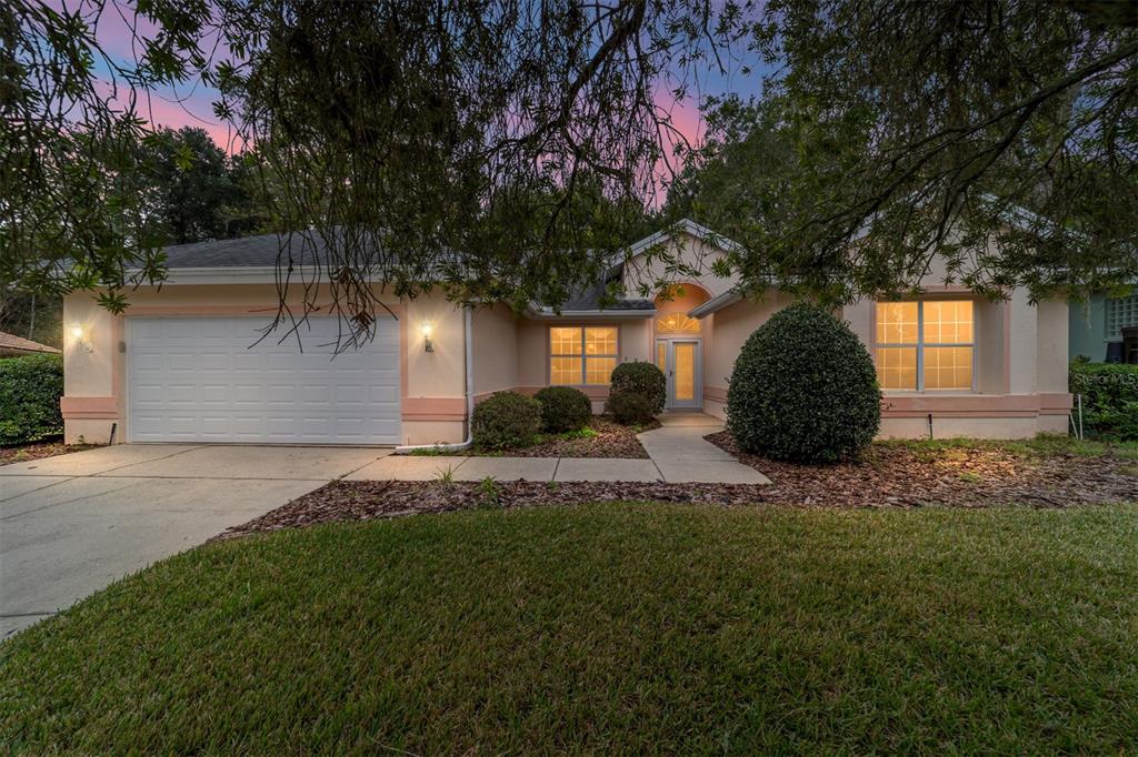 A single-story house with a two-car garage, light-colored stucco walls, and a front walkway — 11481 SW 82ND COURT ROAD, OCALA, FL