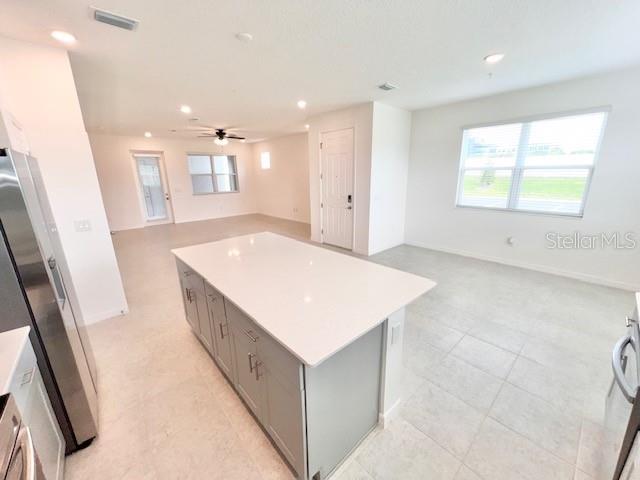 A kitchen with a large white island, gray cabinets, and tile flooring in an open space — 1638 ACCLAIM ROAD, APOPKA, FL