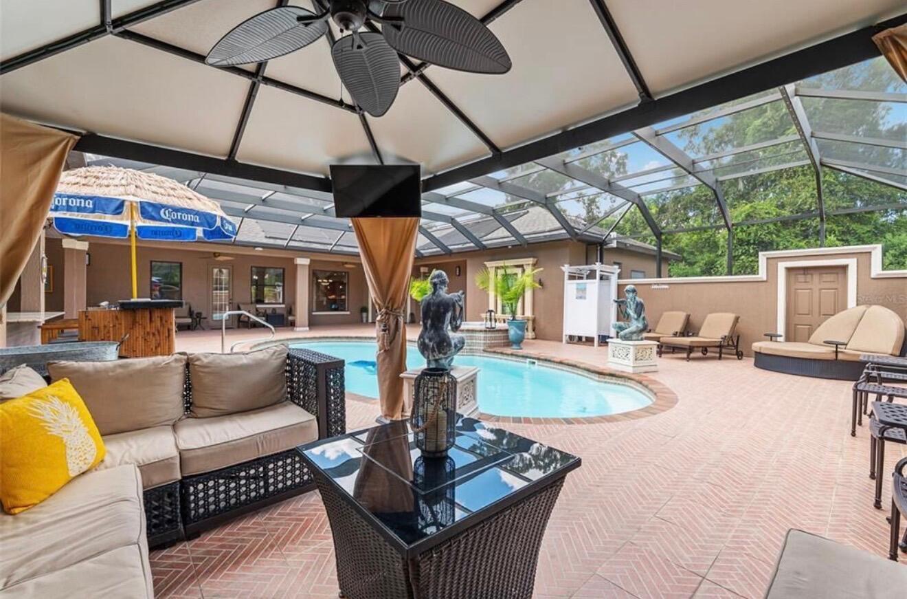 A covered patio features a swimming pool, outdoor furniture, and a tiki-style bar — 2901 SE 28th Lane, Ocala FL 34471, OCALA, FL