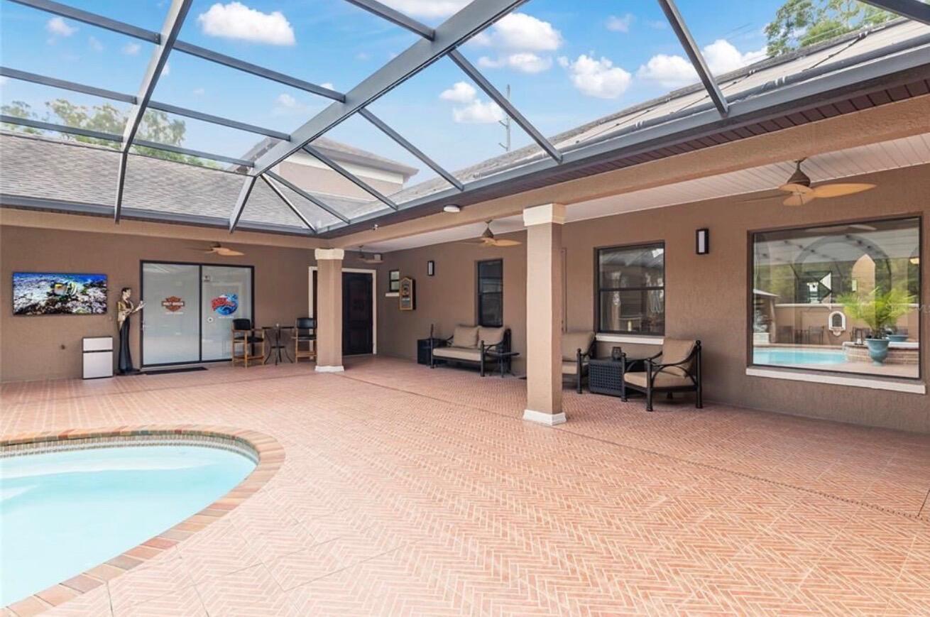 A covered patio features a swimming pool, tiled flooring, and a screened-in enclosure — 2901 SE 28th Lane, Ocala FL 34471, OCALA, FL