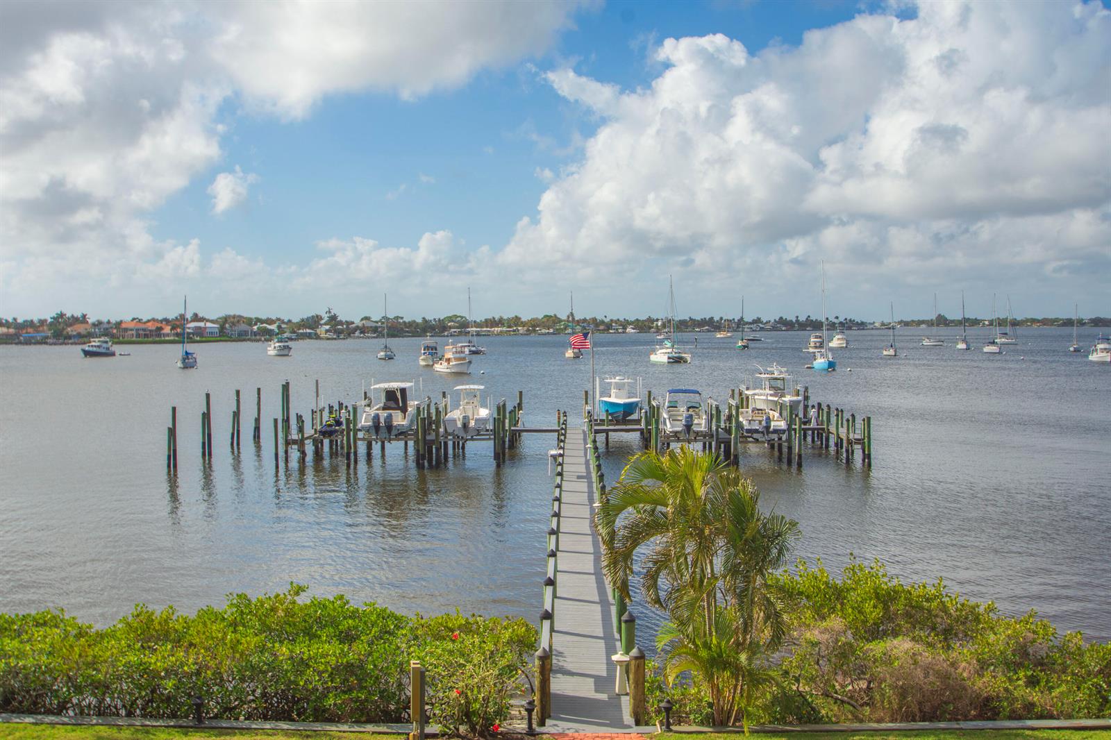 A long wooden dock extends into a bay filled with numerous boats and sailboats — 624 SW St. Lucie Crescent # 206, Stuart FL 34994, STUART, FL
