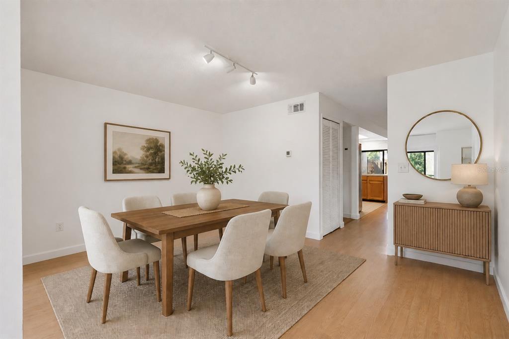 A dining room features a wooden table, six chairs, a rug, and a sideboard mirror — 1329 WINDSOR DRIVE, KISSIMMEE, FL