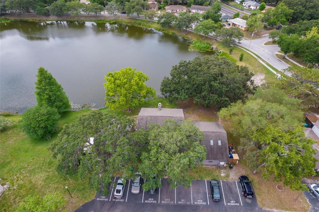 An aerial view shows a multi-unit building with a parking lot beside a lake — 4817 LIGHTHOUSE CIRCLE UNIT 58, ORLANDO, FL