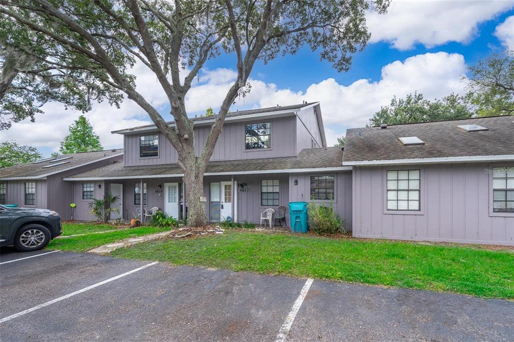 A two-story gray multi-family building with a large tree in the front yard — 4817 LIGHTHOUSE CIRCLE UNIT 58, ORLANDO, FL