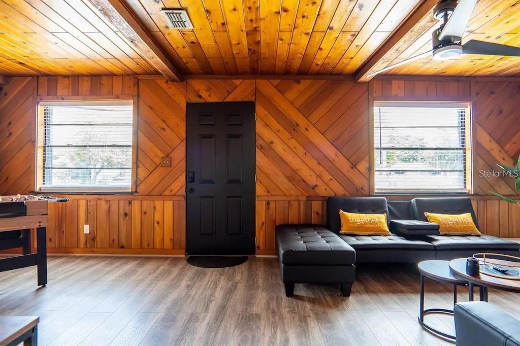 A room with wood-paneled walls, a black door, a black sofa, and a foosball table — 1118 OVERDALE STREET, ORLANDO, FL