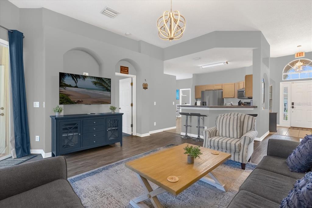 A living room features a blue media console, a striped armchair, and a wooden coffee table — 246 MONTARA DRIVE, DAVENPORT, FL