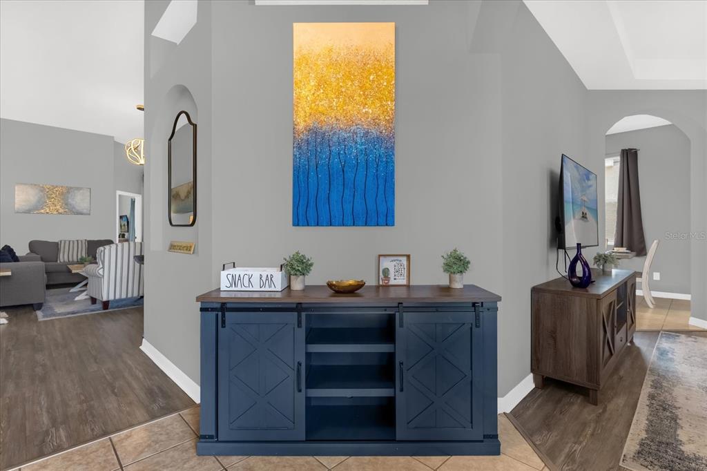 A blue barn-door style console table sits against a gray wall beneath abstract artwork — 246 MONTARA DRIVE, DAVENPORT, FL