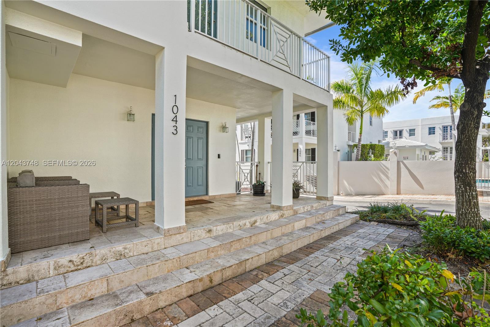 A covered patio with stone steps leads to a blue front door of a building — 1043 SW 9th Ct # 1, Miami FL 33130, MIAMI, FL