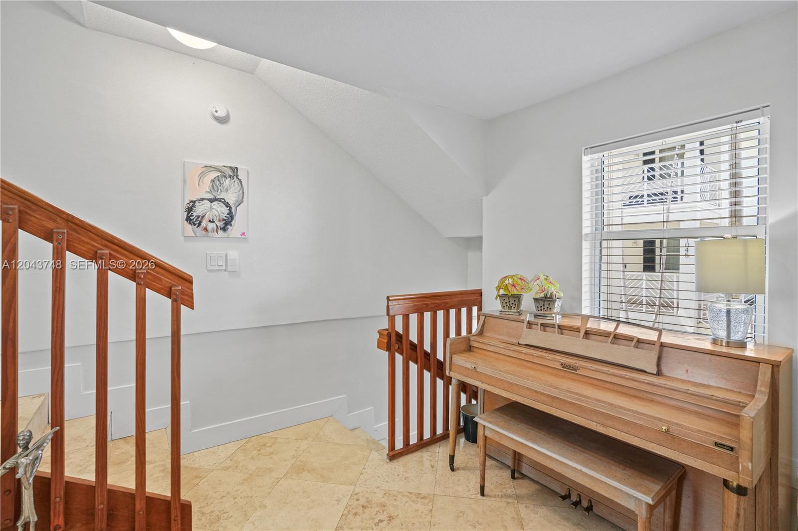 A wooden piano sits on a tiled floor next to a staircase with wooden railings — 1043 SW 9th Ct # 1, Miami FL 33130, MIAMI, FL