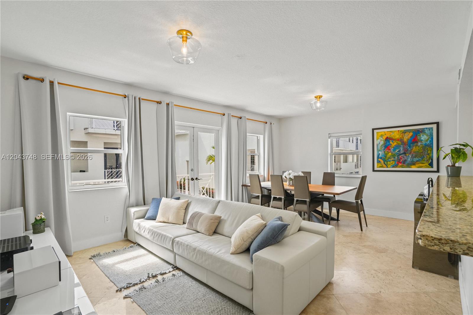 A living and dining area features a white sofa, a wooden table, and tile flooring — 1043 SW 9th Ct # 1, Miami FL 33130, MIAMI, FL