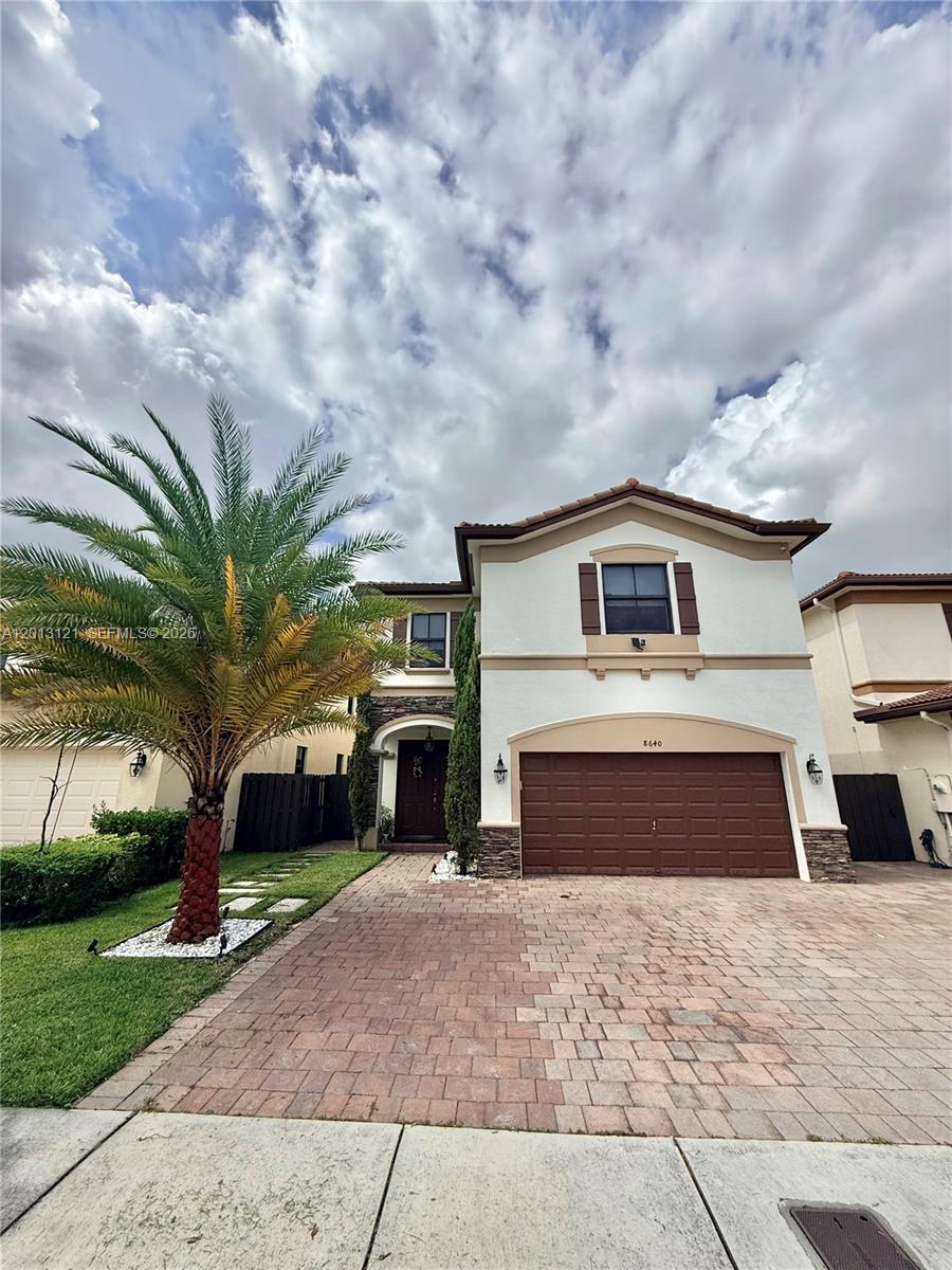 A two-story house with a brown garage door, a palm tree, and a paved driveway — 8640 NW 101st Pl, Doral FL 33178, DORAL, FL