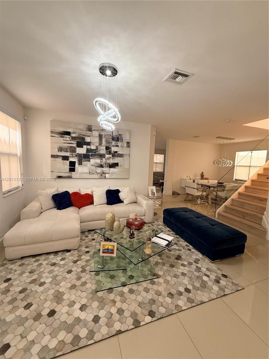 This living room features a white sectional sofa, a glass coffee table, and a patterned rug — 8640 NW 101st Pl, Doral FL 33178, DORAL, FL