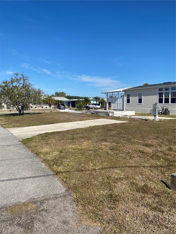 A vacant residential lot features a concrete driveway and an adjacent manufactured home — 6684 ACACIA COURT, NORTH PORT, FL