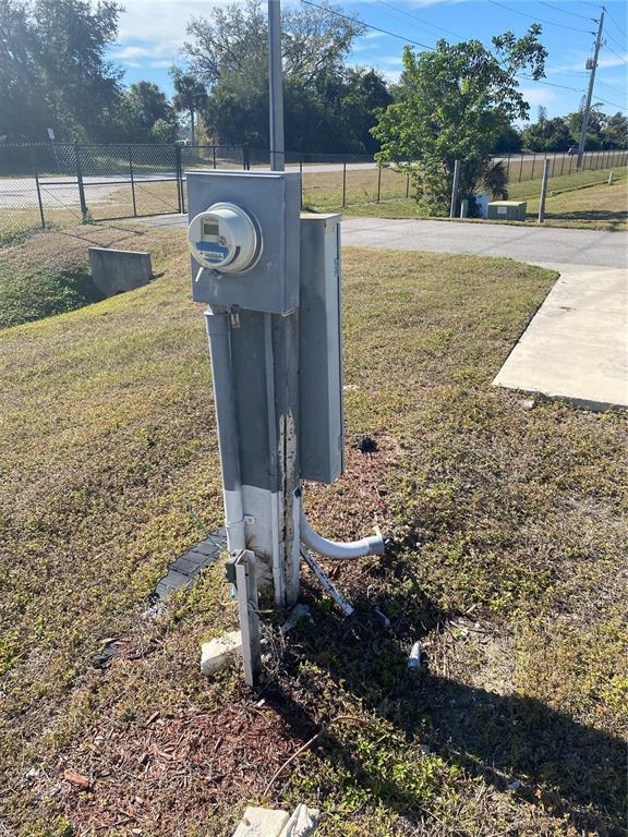 An outdoor electrical meter and service panel stand on a post in a grassy area — 6684 ACACIA COURT, NORTH PORT, FL