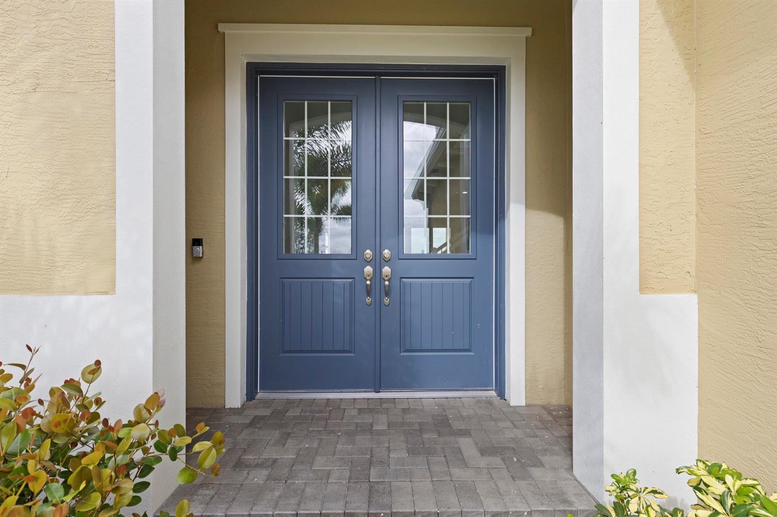 A blue double front door with glass panes is set in a beige stucco entryway — 13548 Spruce Pine Drive, Westlake FL 33470, WESTLAKE, FL