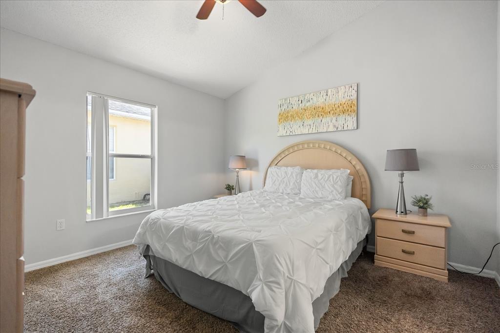 A bedroom features a bed with a white comforter, a headboard, and two nightstands — 316 TIVOLI CIRCLE, DAVENPORT, FL