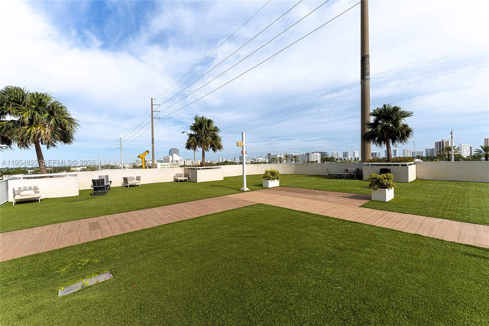 A rooftop terrace features artificial turf, wooden walkways, potted plants, and outdoor seating — 20200 W Dixie Hwy # 903, Miami FL 33180, MIAMI, FL