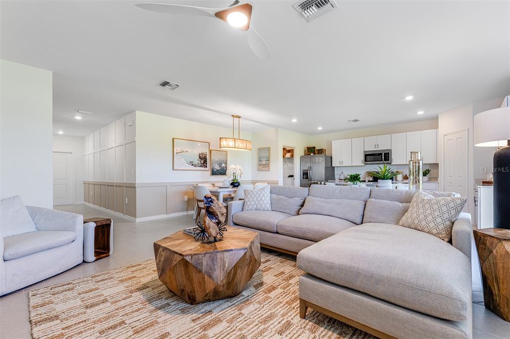 A living room features a sectional sofa, a wooden coffee table, and an open kitchen — 26593 JASPER WAY, PUNTA GORDA, FL