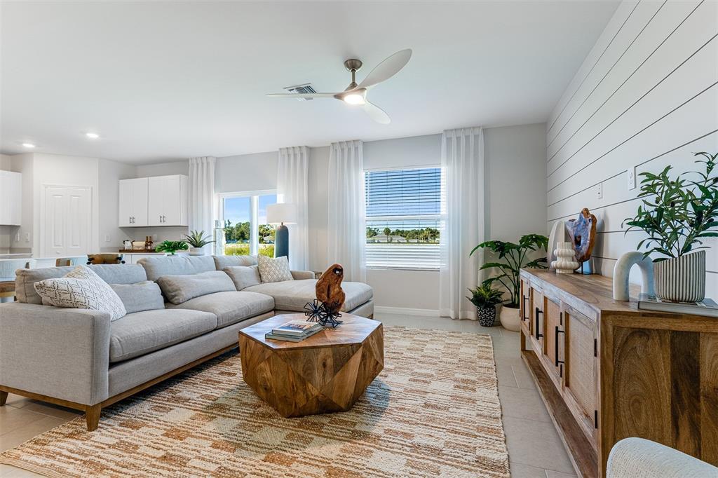 A living room features a sectional sofa, a geometric wooden coffee table, and shiplap walls — 26593 JASPER WAY, PUNTA GORDA, FL