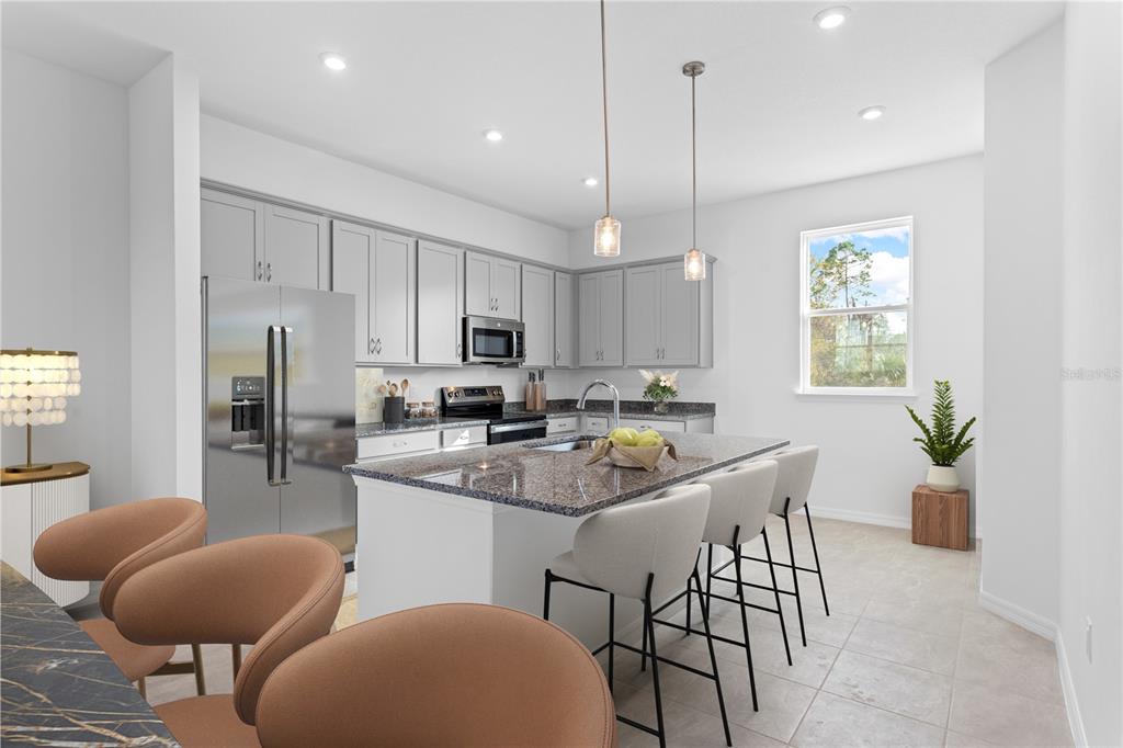 A modern kitchen features gray cabinets, granite countertops, a central island, and stainless steel appliances — 9616 MONTAGUE STREET, WESTCHASE, FL