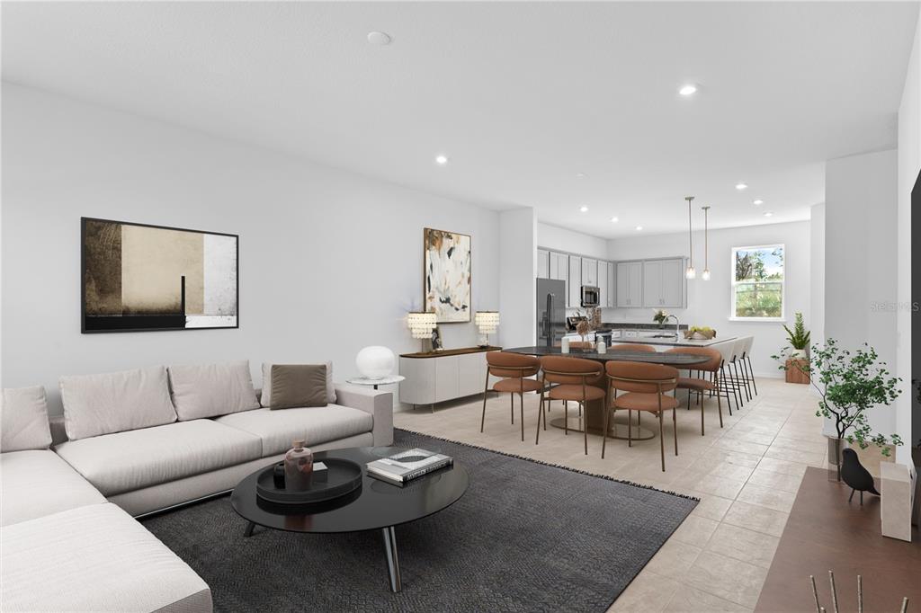 An open-concept living room and kitchen featuring a sectional sofa, dining table, and light cabinetry — 9616 MONTAGUE STREET, WESTCHASE, FL
