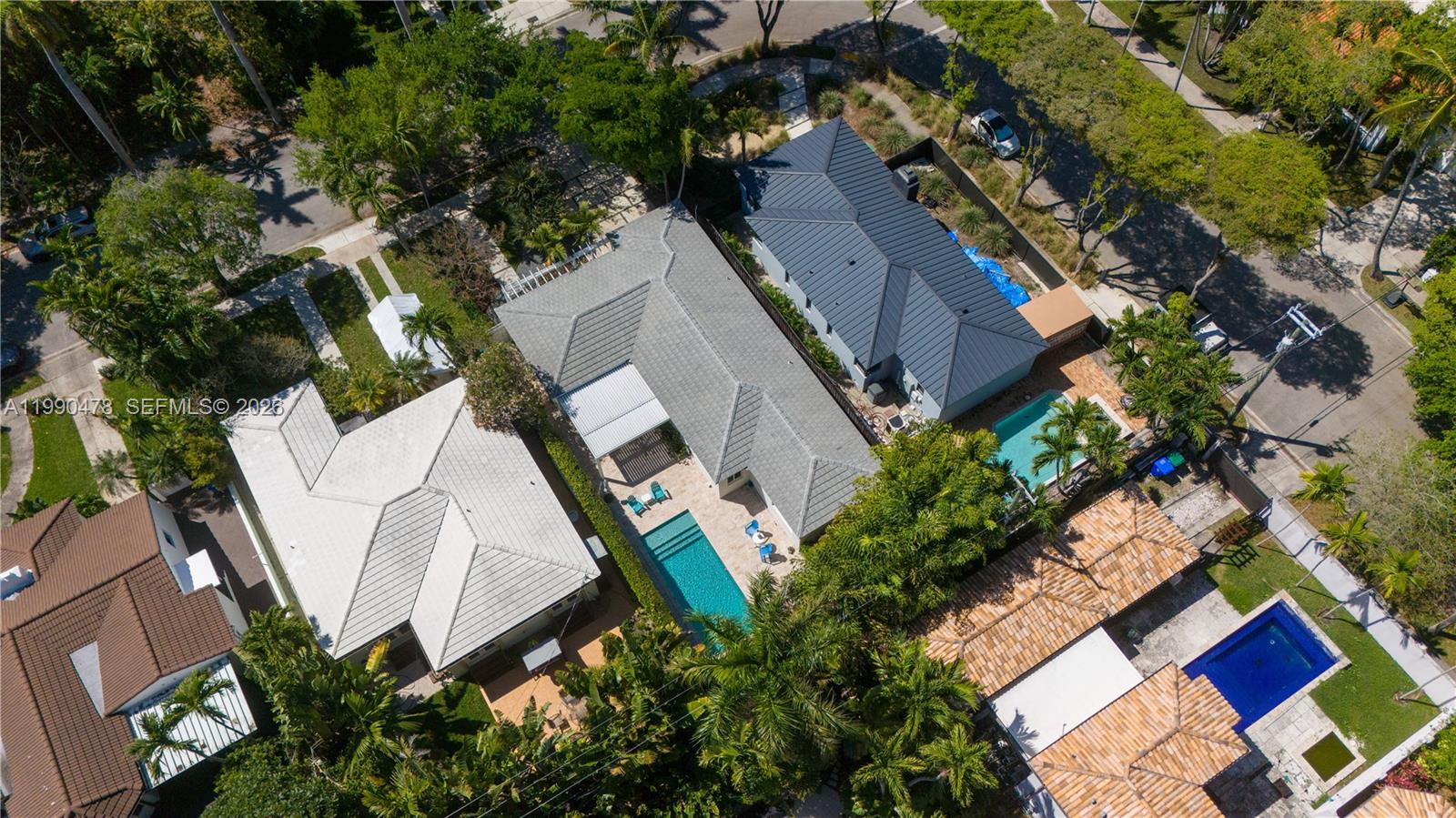 An aerial view shows three residential houses with swimming pools and lush landscaping — 711 NE 72nd Ter, Miami FL 33138, MIAMI, FL
