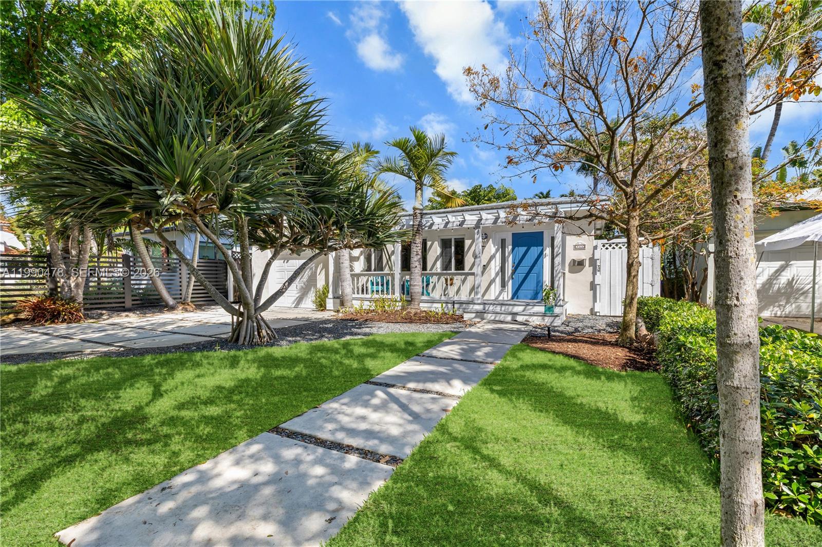 A single-story house with a blue front door, a front porch, and a paved walkway — 711 NE 72nd Ter, Miami FL 33138, MIAMI, FL