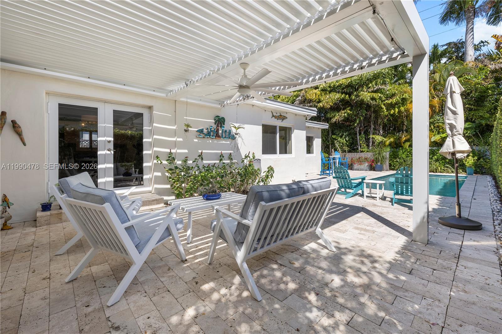 A patio with white furniture, a pergola, and a swimming pool in the backyard — 711 NE 72nd Ter, Miami FL 33138, MIAMI, FL