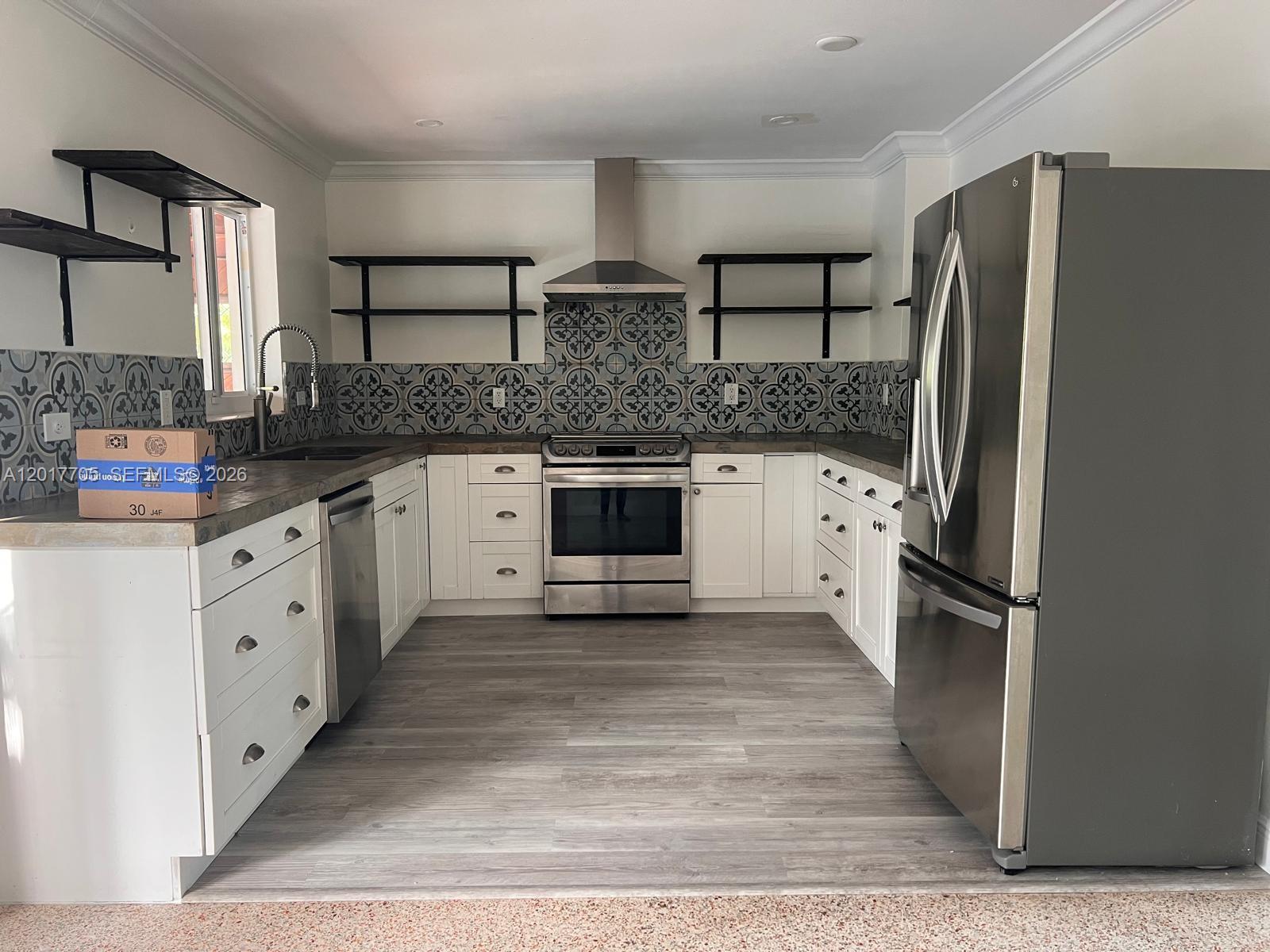 A kitchen features white cabinets, stainless steel appliances, open shelving, and patterned tile backsplashes — 9770 SW 77th Ter, Miami FL 33173, MIAMI, FL