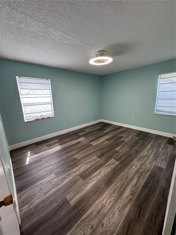 An empty bedroom features light blue walls, wood-look flooring, and a modern ceiling fan light — 700 E AIRPORT BOULEVARD UNIT G4, SANFORD, FL
