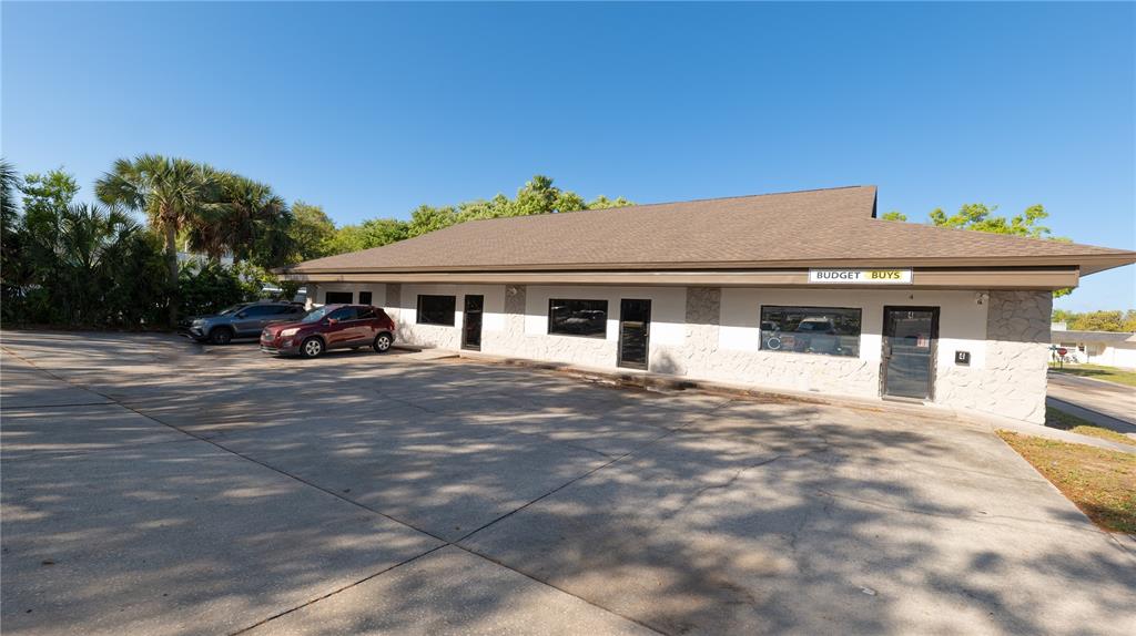 A single-story commercial building with a stone facade and a large paved parking lot — 190 PATRICIA AVENUE UNIT 4, DUNEDIN, FL