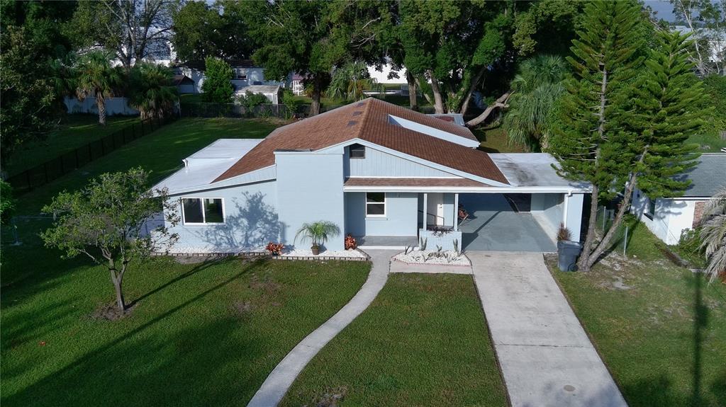 An aerial view of a light blue single-story house with a brown roof and carport — 2221 20TH STREET NW, WINTER HAVEN, FL