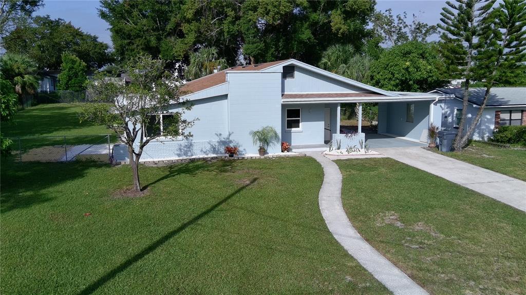 A light blue single-story house with a carport, a front walkway, and a grassy yard — 2221 20TH STREET NW, WINTER HAVEN, FL