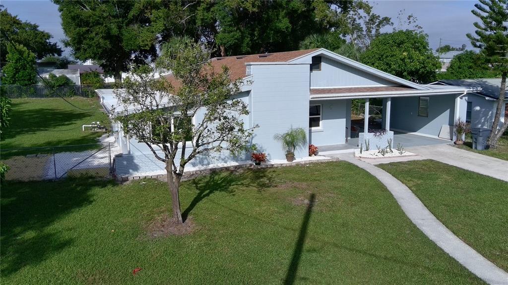 An aerial view of a light blue single-story house with a carport and grassy yard — 2221 20TH STREET NW, WINTER HAVEN, FL