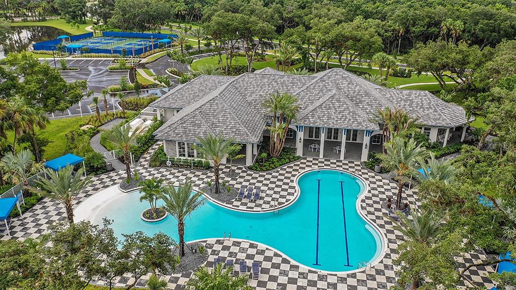 An aerial view shows a community clubhouse with a large pool and tennis courts nearby — 21201 WACISSA DRIVE, VENICE, FL